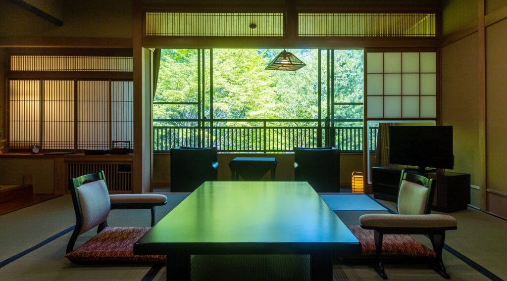 つつじ亭 本館の客室。窓の外に自然林の庭が広がる