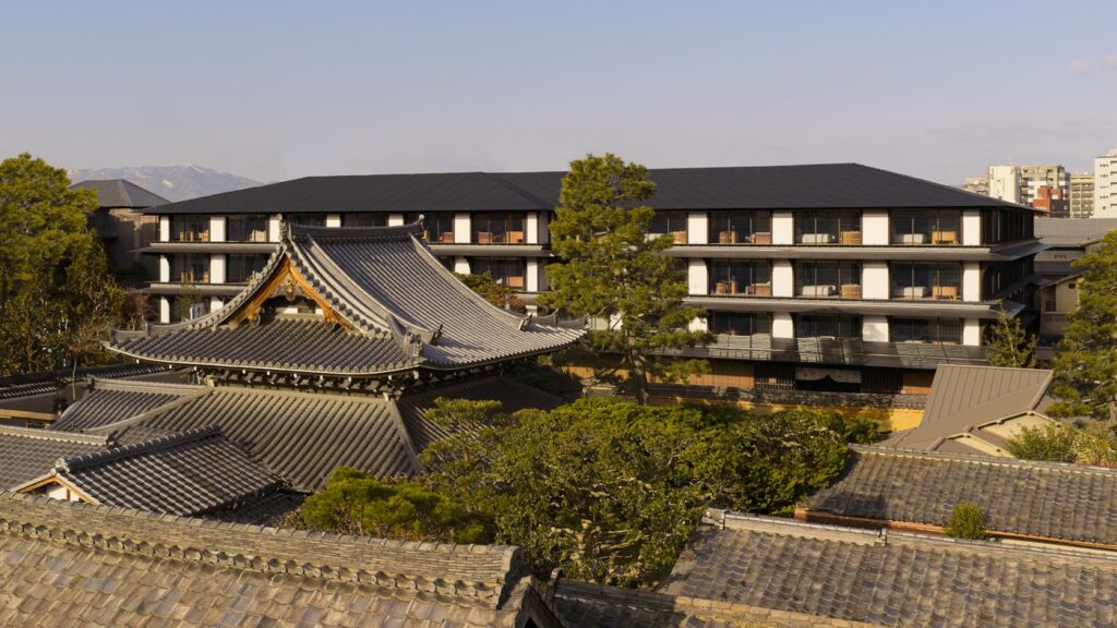 宮川町の寺社の屋根の向こうに建つカペラ京都